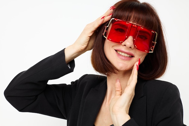 Portrait of a woman in red with stylish glasses a leather suit black jacket isolated background