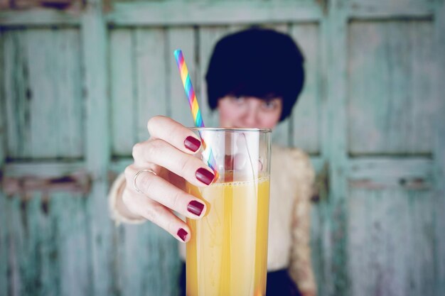 Photo portrait of woman showing drink glass