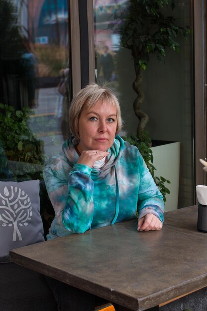 Portrait of a woman sitting in a cafe Outside at a table waiting