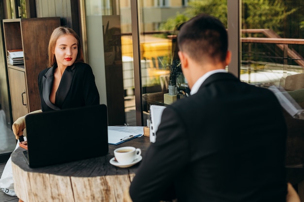 Portrait of woman sitting in cafe with man. Business meeting