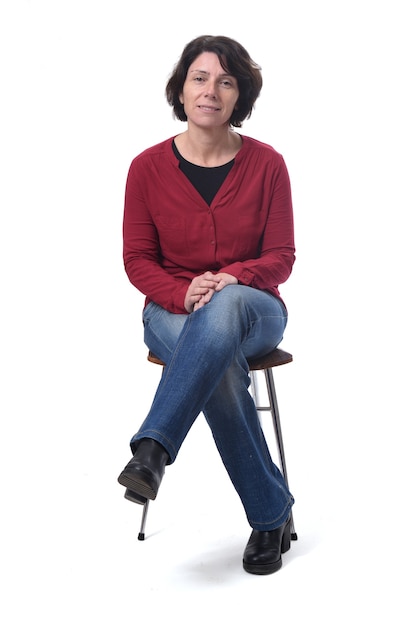 Portrait of a woman sitting on a chair on white background, legs crossed