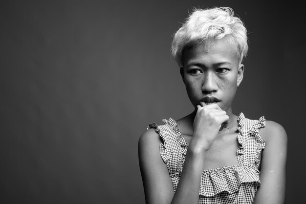 Portrait of woman standing against black background