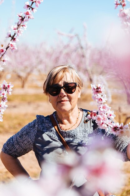 Portrait of woman standing by pink flowering plants