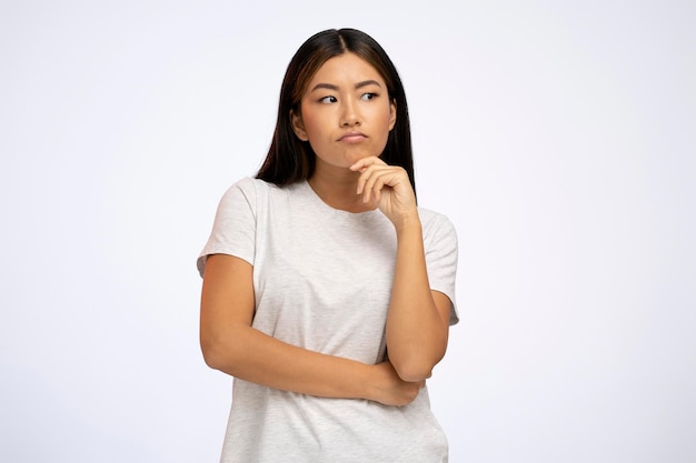 Portrait of woman standing with thoughtful serious smart expression pondering answer