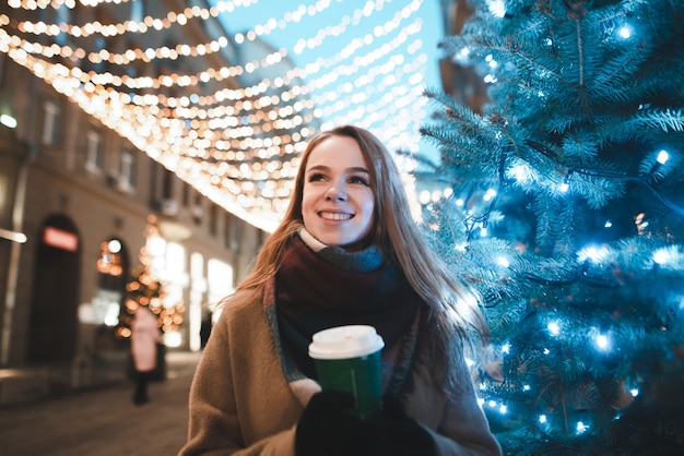 portrait woman on street with cup of coffee