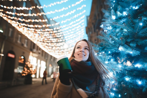 portrait woman on street with cup of coffee