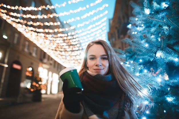 portrait woman on street with cup of coffee