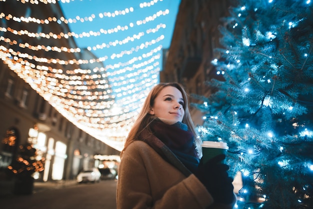 portrait woman on street with cup of coffee