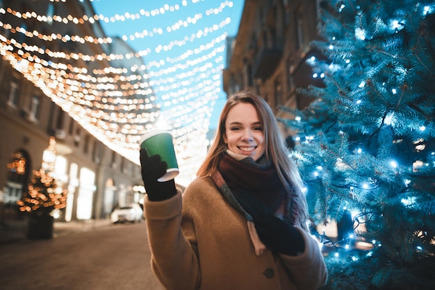 portrait woman on street with cup of coffee