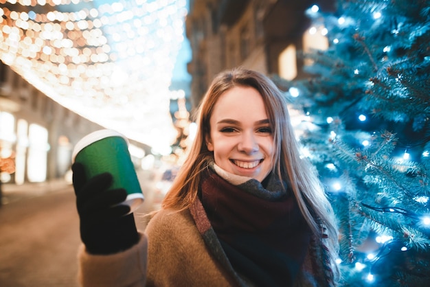 portrait woman on street with cup of coffee