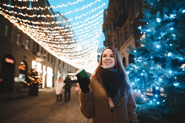 portrait woman on street with cup of coffee