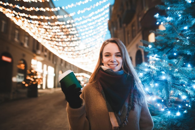 portrait woman on street with cup of coffee