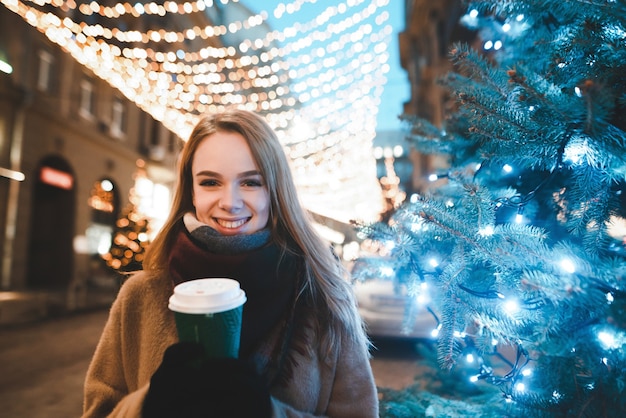 portrait woman on street with cup of coffee