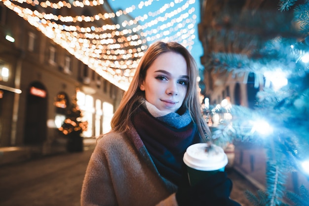 portrait woman on street with cup of coffee