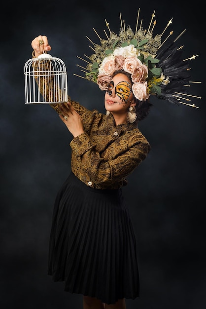 Portrait of woman in sugar skull makeup holding a cage day of the dead makeup Catrina portrait