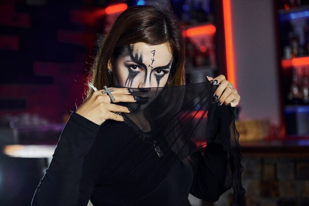 Portrait of woman that is on the thematic halloween party in scary makeup and costume.