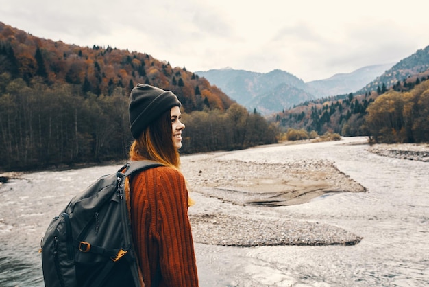 Portrait of woman traveler in mountains outdoors near river landscape cropped view