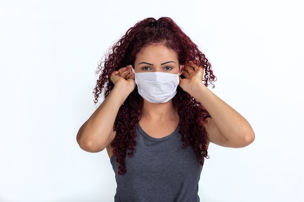 Portrait of a woman wearing or removing her face mask in times of pandemic