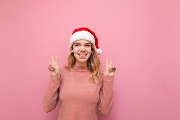 portrait woman wearing Santa hat listening to music in wireless headphones