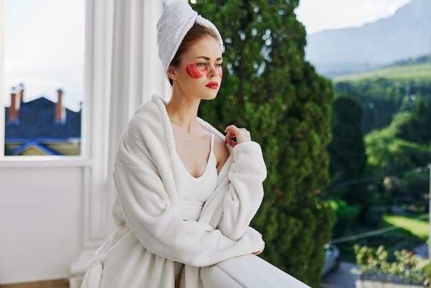 Photo portrait woman in a white robe the balcony overlooks the mountains unaltered