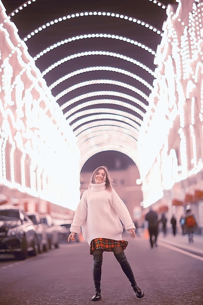 portrait of a woman white sweater winter, seasonal outside city walk in the evening city