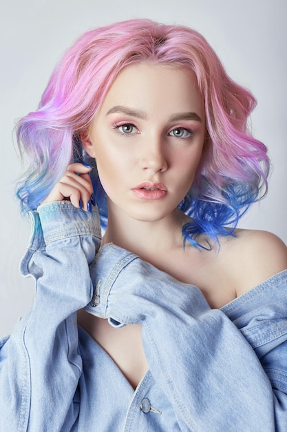 Portrait of a woman with bright colored flying hair, all shades of purple. Hair coloring, beautiful lips and makeup. Hair fluttering in the wind. Sexy girl with short  hair. Professional coloring