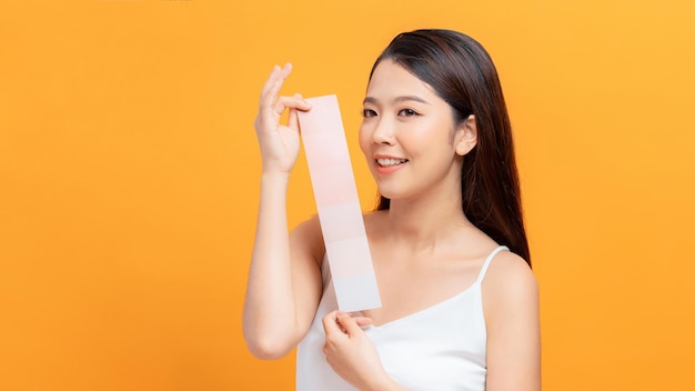 Portrait woman with clear skin holding skin tone different colors near her face