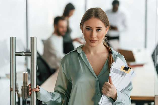 Photo portrait of woman with documents team of office workers are together indoors