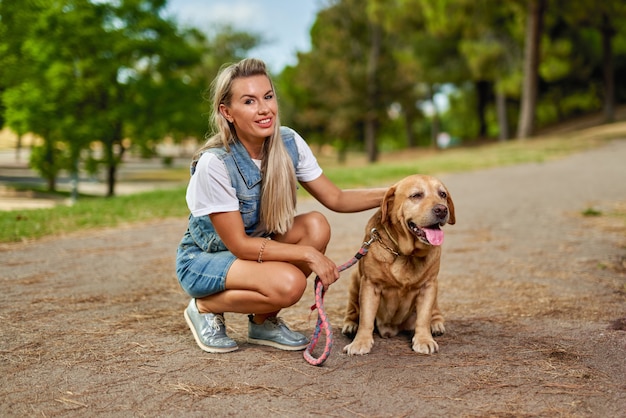 Portrait of a woman with a dog in the park.