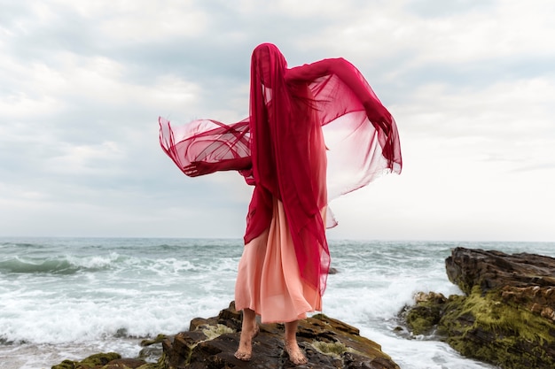 Portrait of woman with face covered by veil at the beach