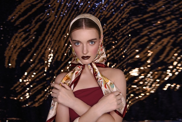 portrait woman with glamourous make up wearing a golden scarf