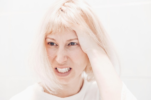 Portrait of a woman with a headache on a white background