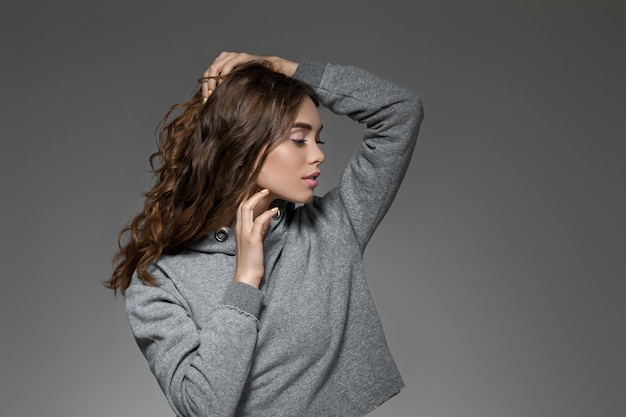 Portrait of woman with long hair in gray sweater