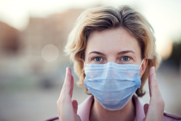 A portrait of woman with medical face mask outdoor. People, healthcare and medicine concept