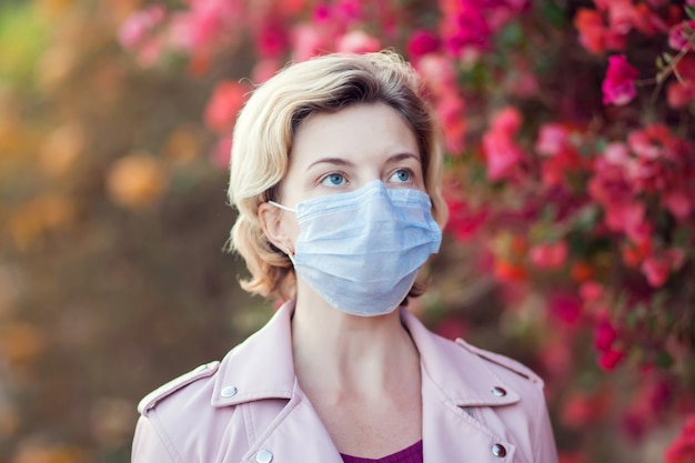 A portrait of woman with medical face mask outdoor. People, healthcare and medicine concept