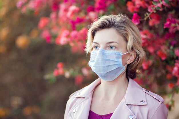 A portrait of woman with medical face mask outdoor. People, healthcare and medicine concept