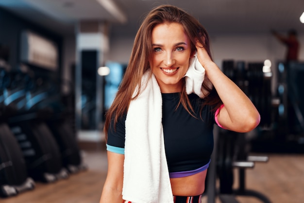 Portrait of a woman with towel working out in a gym