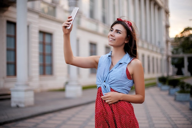 Portrait of wonderful caucasian woman taking selfie with smartphone in europe brunette female