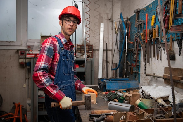 Portrait of a worker in a factory with working tools in the workbench