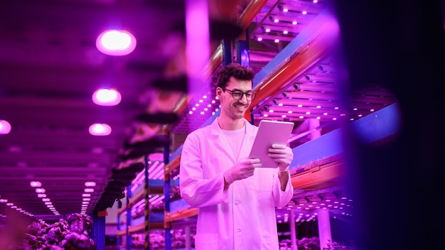 Portrait of worker with tablet on aquaponic farm, sustainable business and artificial lighting.