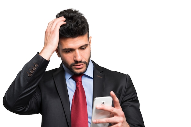 Portrait of a worried man looking at his smartphone