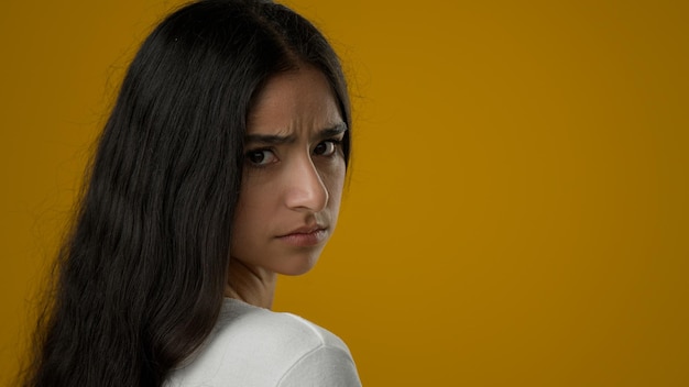 Portrait in yellow studio sad upset stressed indian ethnic woman suffer with anxiety female anxious