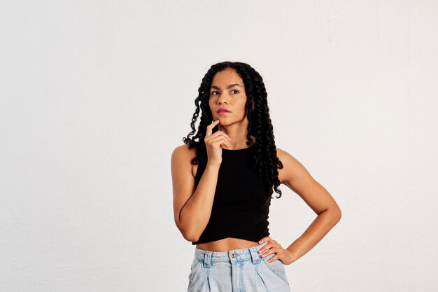 Portrait of a young adult woman thinking looking away with her hand on her chin in a studio shot