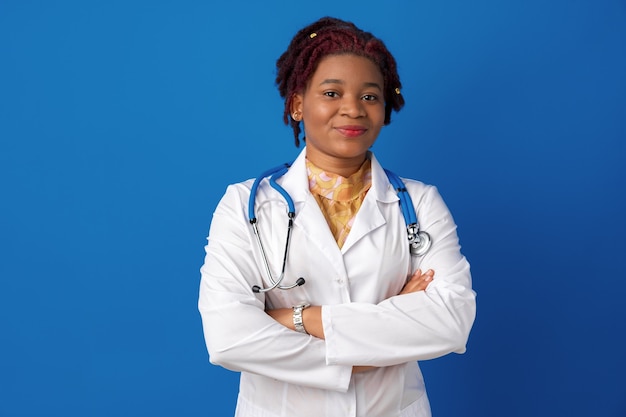 Portrait of a young african american woman doctor against blue background