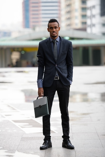 Portrait of young African businessman in the city streets outdoors