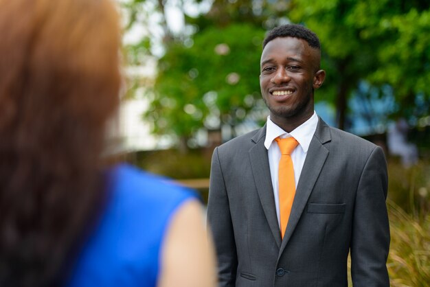 Portrait of young African businessman and young businesswoman with red hair together