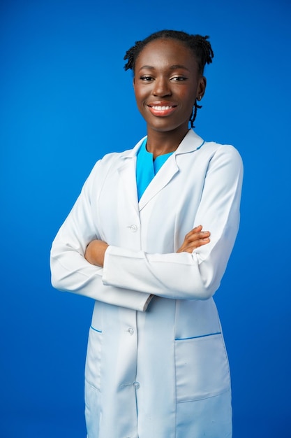 Portrait of young african female doctor in blue studio