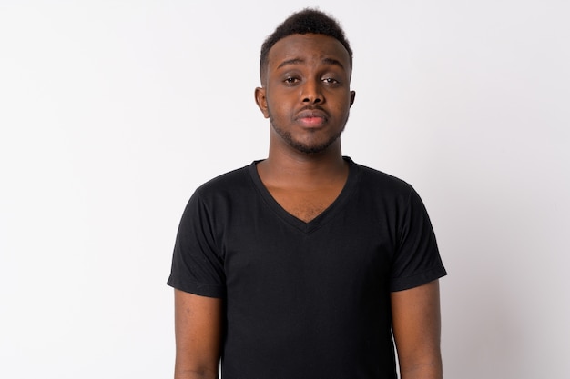 Portrait of young African man against white wall