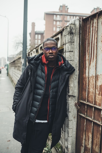 Portrait of young african man standing in the street and looking further 