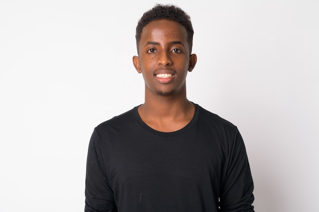 Portrait of young African man with Afro hair against white wall